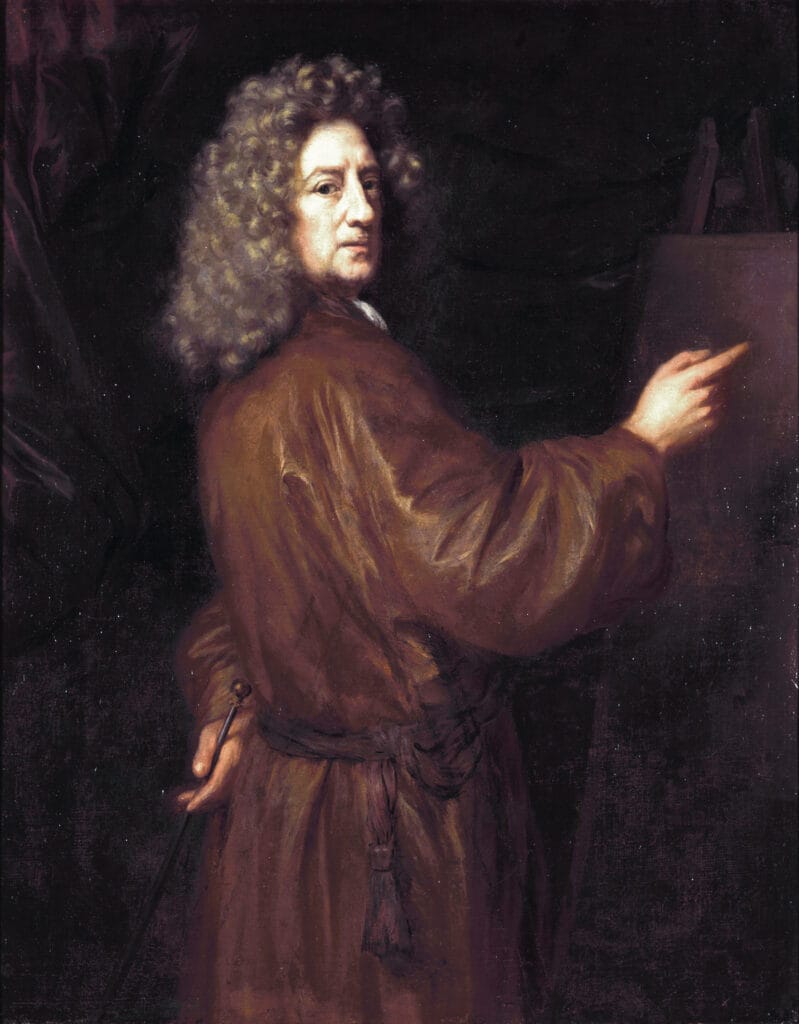 A man with curly hair, in a brown robe, stands by an easel pointing at a canvas. The setting is dark and dramatic, conveying a contemplative tone.