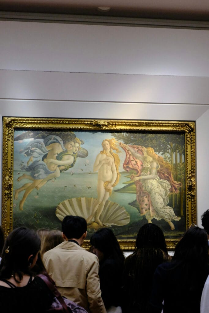Museum visitors gathered in front of Sandro Botticelli’s The Birth of Venus in a gallery.